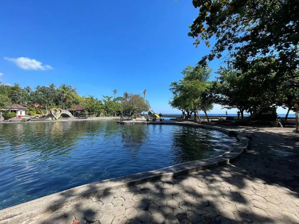 Air Sanih Bali freshwater spring pool by the sea with clear water, trees, and coastal views near Lovina